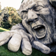 Illustration for article titled Scary giant man crawls out from the ground in shocking outdoor sculpture